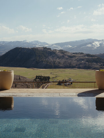 Infinity pool at Amangani overlooking the Wyoming landscape, with snow-capped mountains in the distance.
