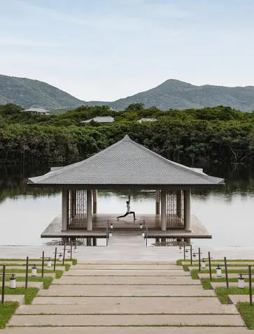 Yoga pavilion at Amanoi overlooking calm waters with verdant Vietnamese landscape beyond.