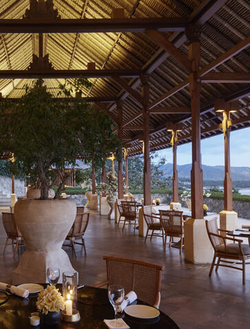 Restaurant dining area at Amankila resort with open-sided pavilion overlooking Bali coastline.