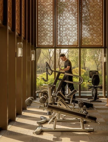 Fitness centre at Amanyangyun with exercise bikes lined along windows overlooking greenery.