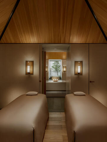 Spa treatment room at Amanyangyun with twin massage beds and warm wooden ceiling.
