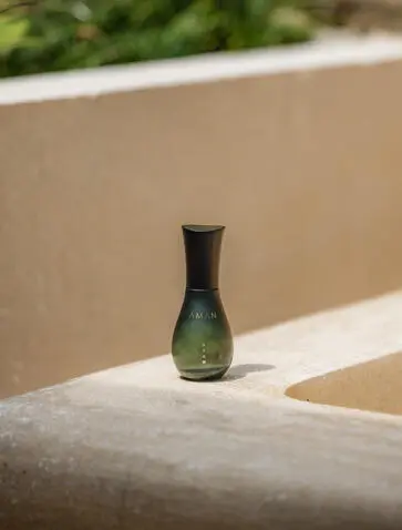Green glass bottle on stone ledge at Amanjiwo, Java, Indonesia.