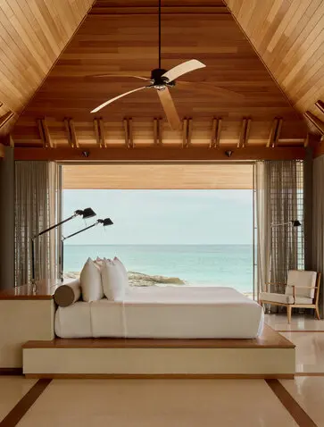 Spa villa bedroom at Amanyara with vaulted wooden ceiling, freestanding bath overlooking turquoise waters, Turks and Caicos.