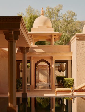 Amanbagh accommodation pool pavilion exterior with domed architecture and water reflection.