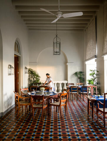 Amangalla's colonial-style dining room with wooden beam ceiling, geometric floor tiles and period furnishings.
