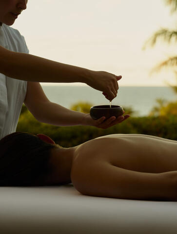 Terapeuta realizando masaje en espalda de huésped al atardecer en Amanera resort, República Dominicana.