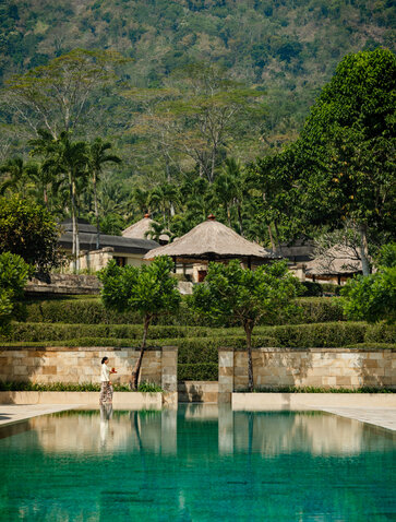 Amanjiwo's pavilions overlook an emerald plunge pool surrounded by dense forest vegetation.