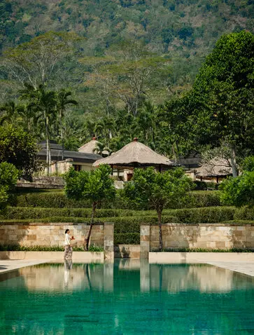 Amanjiwo's pavilions overlook an emerald plunge pool surrounded by dense forest vegetation.