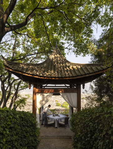 大研安缦度假村中传统中式亭阁，绿叶环绕，阳光透过树叶洒落。