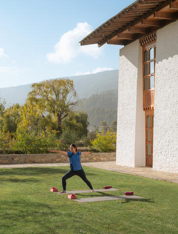 Yoga class on the lawn at Amankora's Bumthang Lodge, with mountains beyond.