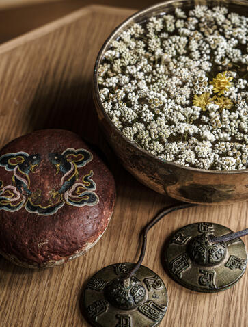 Spa detail at Amankora showing decorative bowls with natural ingredients and ornamental objects on wooden surface.