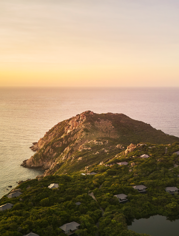 Aerial view of a forested headland at sunset, Amanoi, Vietnam.