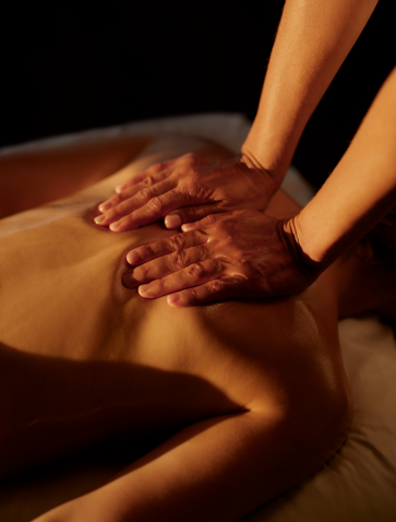 Therapist's hands applying warm clay treatment to guest's back at Amanera wellness spa, Dominican Republic.