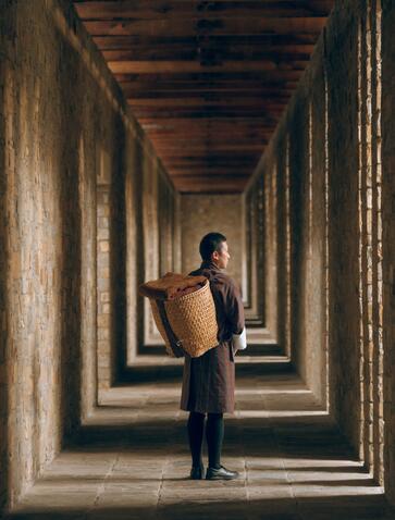 Guest standing in a colonnade of repeating arches at Amankora, Bhutan.