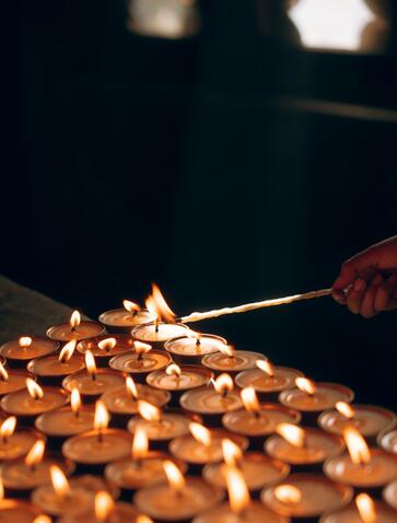 Butter lamp being lit during an evening ceremony at Amankora, Bumthang, Bhutan.