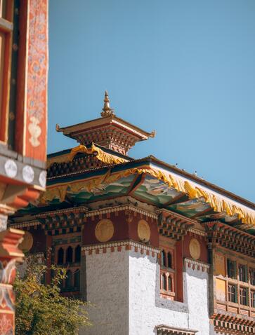 Ornate wooden temple roof with gold detailing at Amankora's Bumthang Lodge, Bhutan.