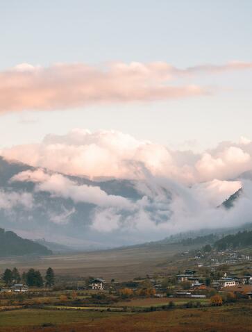 Snow-capped mountain rising above a valley settlement at Amankora, Gangtey, Bhutan.