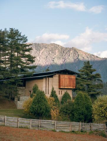Amankora residence in Gangtey with mountain backdrop and wooden architecture, Bhutan.