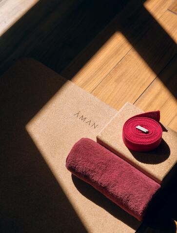 Yoga mat and cushion at Amankora's Paro Lodge, arranged on wooden flooring.