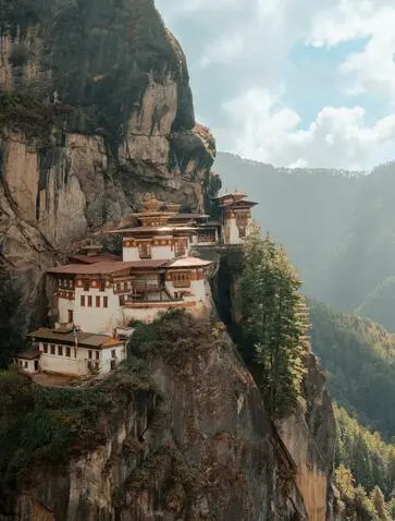 Taktshang Monastery perched on a cliff edge at Amankora, Paro, Bhutan, with mountains in the background.