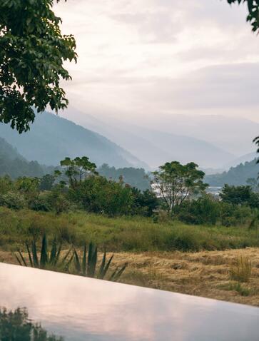 Punakha valley pool at Amankora with mountain views and lush greenery.