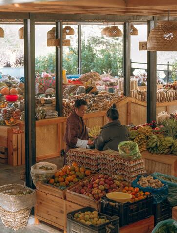 Vendor arranging fresh produce at Thimphu Farmers Market during Amankora tour, Bhutan.