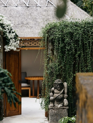 Entrance to principal bedroom at Aman Villas at Nusa Dua, with wooden doors and ivy-covered walls.