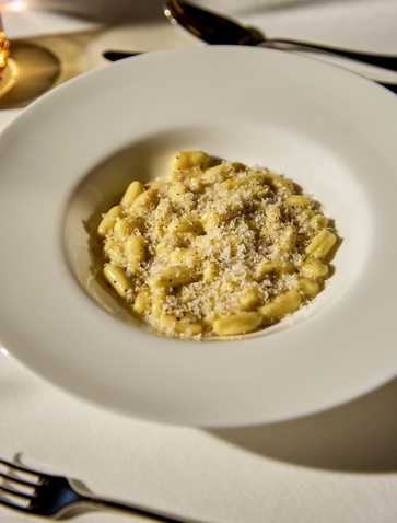 Risotto ai frutti di mare servito presso Aman Venice, piatto tradizionale veneto in bianco piatto.