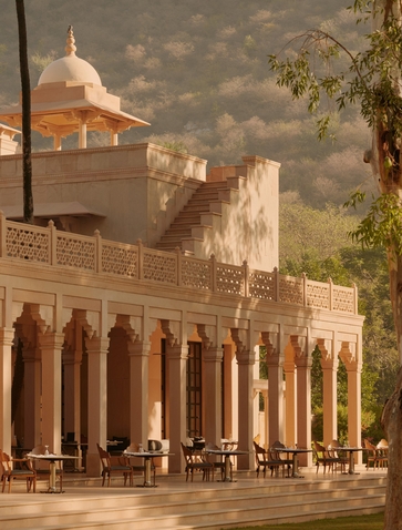 Amanbagh's main building exterior with sandstone columns and traditional Indian architecture in warm afternoon light.