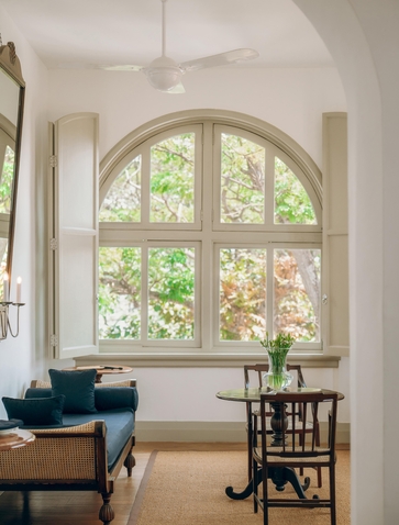 Suite interior at Amangalla with arched window overlooking gardens and period furnishings.