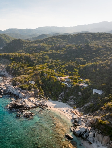 Aerial view of Amanoi ocean pool residence overlooking turquoise waters and forested Vietnamese coastline.