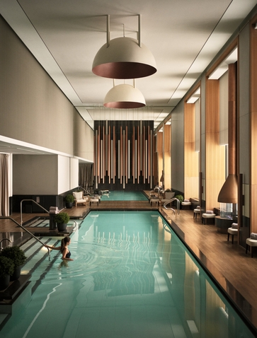 Swimming pool at Aman New York with warm lighting and floor-to-ceiling windows.