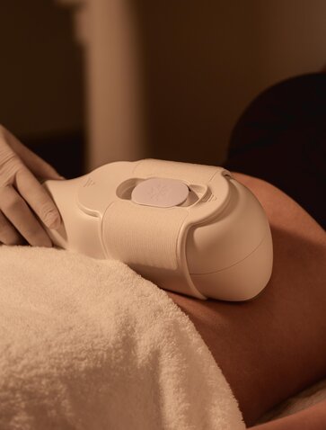 Cool Sculpting treatment being applied to client's arm at Aman Nai Lert Bangkok wellness clinic.