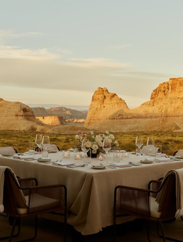 Outdoor dining table at Amangiri with desert rock formations at sunset.