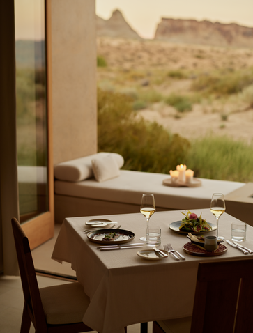 Sala da pranzo privata ad Amangiri con tavolo, sedie in legno e vista sul paesaggio desertico.