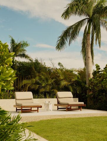 Hill Casita at Amanera with loungers on manicured lawn surrounded by tropical palms and vegetation.