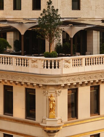 Aman New York's Crown Building exterior featuring neoclassical architecture with arched colonnade and cream-coloured facade.