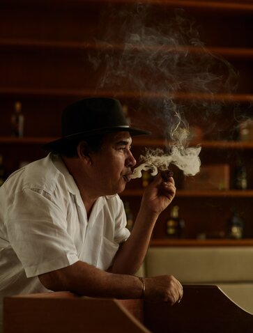 Man smoking a cigar during a cigar-making experience at Amanera, Dominican Republic.