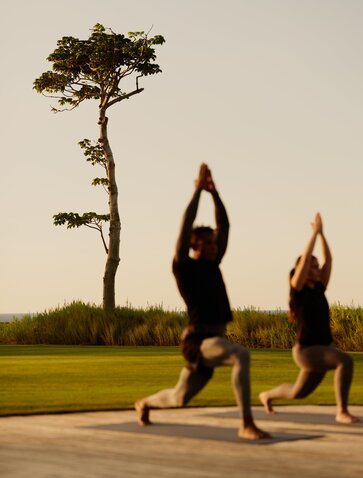 Deux femmes pratiquent le yoga en plein air à Amanera, la station balnéaire dominicaine.