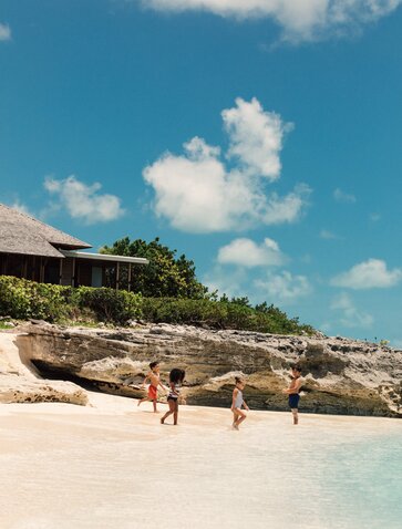 Children playing on white sand beach at Amanyara, Turks and Caicos.