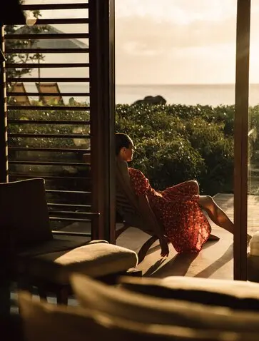 Guest relaxing on the Ocean Pavilion terrace at Amanyara, Turks and Caicos, overlooking tropical landscape.