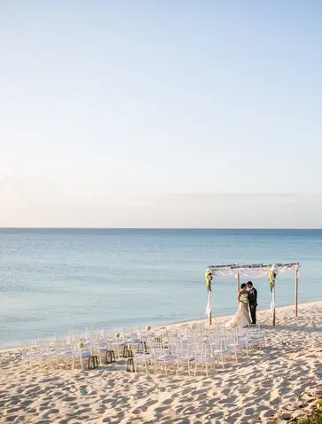 Couple exchanging vows at a beach wedding ceremony on the sand at Amanyara, Turks and Caicos.