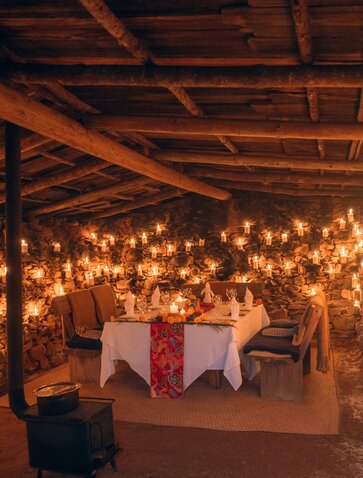 Candlelit potato shed at Amankora with warm string lights and traditional Bhutanese textiles draped overhead.