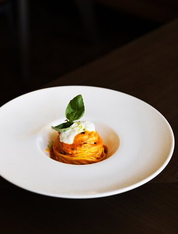 Spaghetti al Pomodoro with Burrata at Aman Rosa Alpina, topped with fresh basil and tomato sauce.