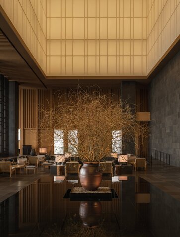 Garden Lounge at Aman Tokyo with wooden ceiling, cork walls, and minimalist seating arrangement.
