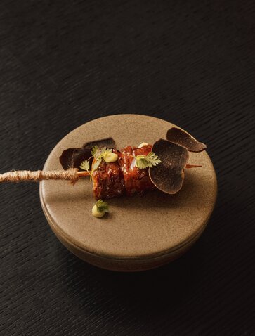 Piatto di ceramica con spiedino di ingredienti raffinati presso Aman Venice.
