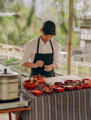 Chef preparing Bhutanese dishes during a cooking class at Amankora, Punakha.