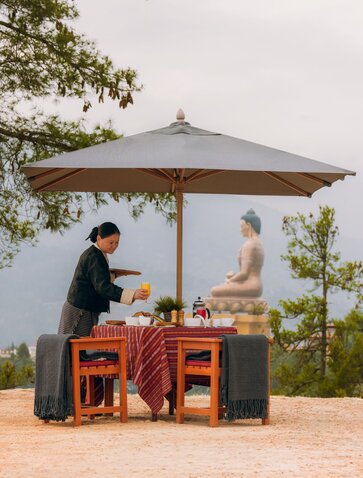 Breakfast service at Amankora with Buddha Dordenma statue visible in the distance, Thimphu.