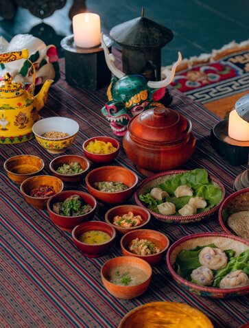 Farmhouse dining spread at Amankora featuring traditional Bhutanese dishes in colourful bowls arranged on a wooden table.