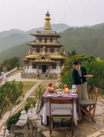Breakfast table at Amankora overlooking Khamsum Chorten and Punakha valley in Bhutan.
